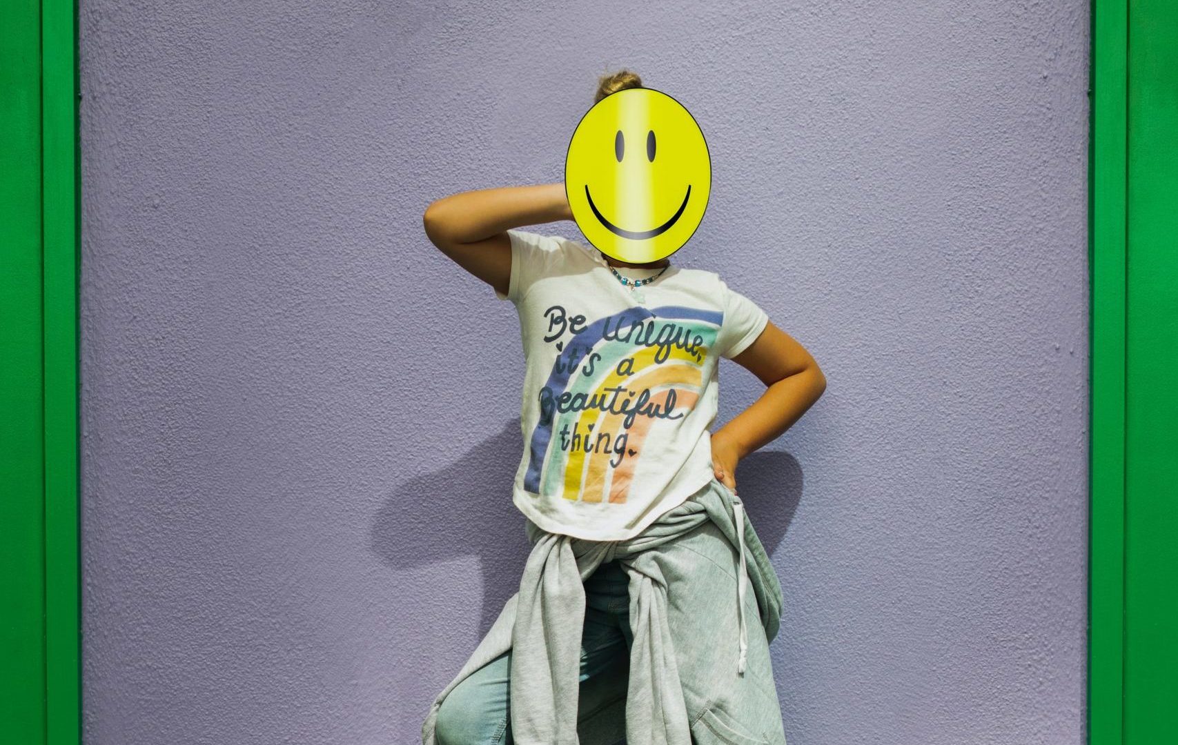 Jeune fille souriante avec un masque smiley, symbole de l'accueil téléphonique